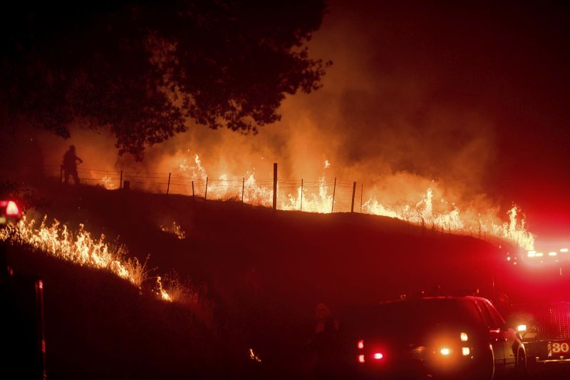 Flames from a backfire burn as CalFire crews battle a wildfire near Mariposa, Calif.