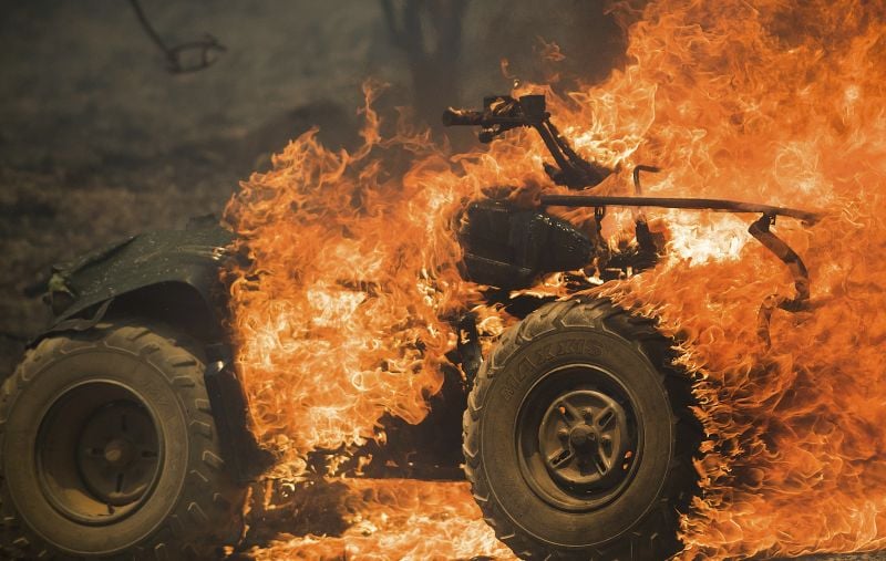 Flames from a wildfire consume an all-terrain vehicle near Oroville, Calif.