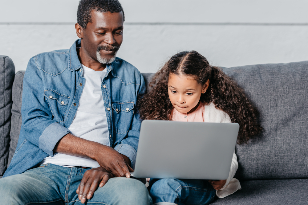 African American man and child using home computer