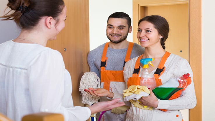 Woman homeowner meeting cleaning crew young man and young woman