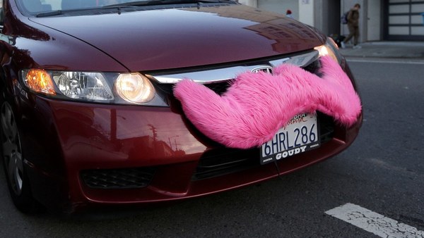 Car with Lyft pink mustache on front bumper