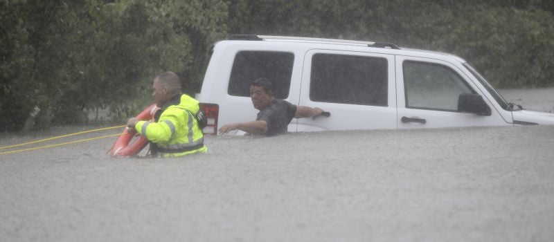 man waits to be rescued after his car got stuck in floodwaters from Tropical Storm Harvey