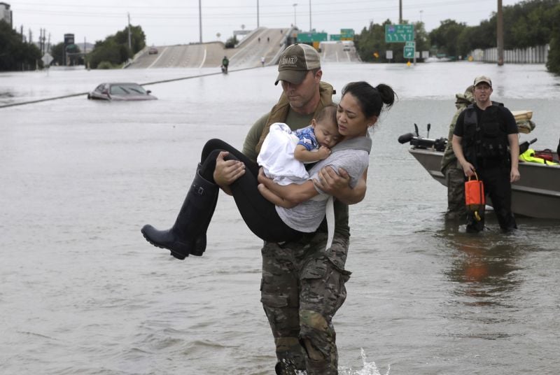 Houston Police SWAT officer Daryl Hudeck carries Catherine Pham and her 13-month-old son Aiden after rescuing them from their home surrounded by floodwaters from Tropical Storm Harvey 