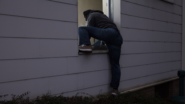 Burglar entering home through window