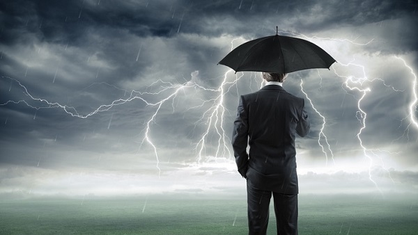 Man with an umbrella looking at lightning and storm clouds