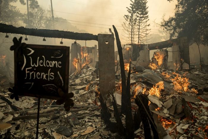 Flames consume a home on Via Arroyo as a wildfire rages in Ventura, Calif.