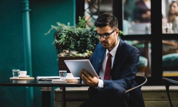 Man scrutinizing information on a tablet.