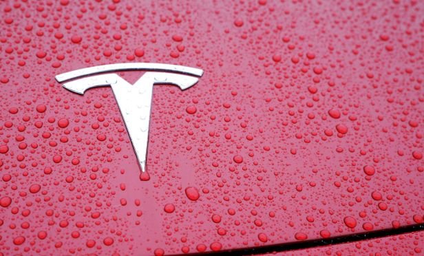 Tesla emblem on a red car.