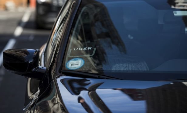 The Uber logo is seen on the windshield of a vehicle