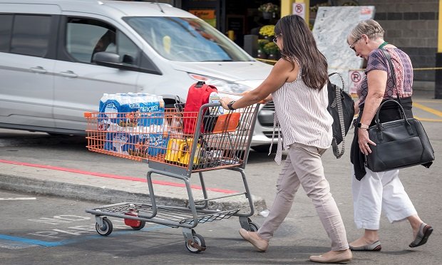 A customer pushes a shopping cart with bottled water, flashlights, and batteries in a Home Depot Inc. parking lot in Emeryville, California, U.S., on Tuesday, Oct. 8, 2019. (Photo: David Paul Morris/Bloomberg)
