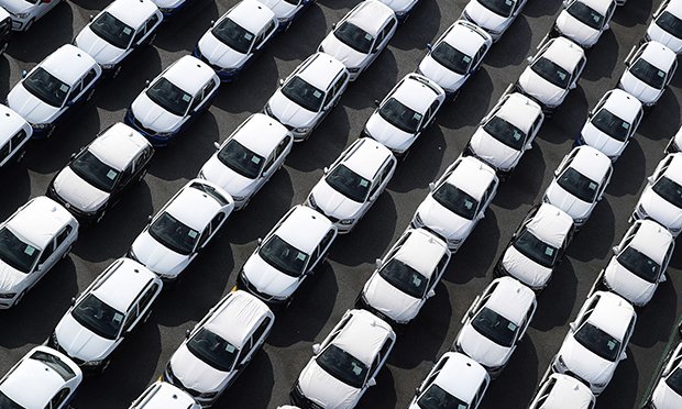 Rows of newly manufactured Volkswagen AG (VW) and Audi AG automobiles sit parked before shipping outside the VW factory at the port in Emden, Germany, on Friday, March 9, 2018. (Credit: Krisztian Bocsi/Bloomberg)