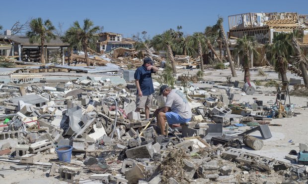 Residents survey debris after Hurricane Michael hit in Mexico Beach, Florida, U.S., on Friday, Oct. 12, 2018. Search-and-rescue teams found at least one body in Mexico Beach, the ground-zero town nearly obliterated by Hurricane Michael, an official said Friday as the scale of the storm's fury became ever clearer. Photographer: Zack Wittman/Bloomberg