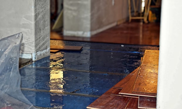 A wooden floor is torn apart after being damaged by water.