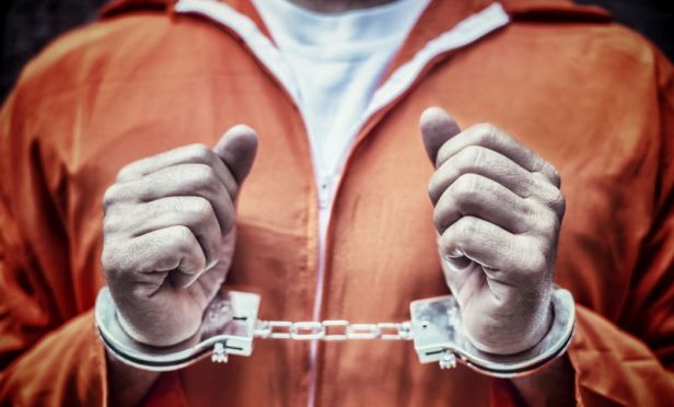 Handcuffed Prisoner in Orange Coveralls