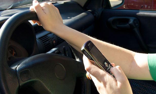 Woman driving while texting.