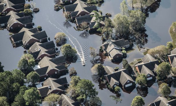 A boat makes it way past flooded property.