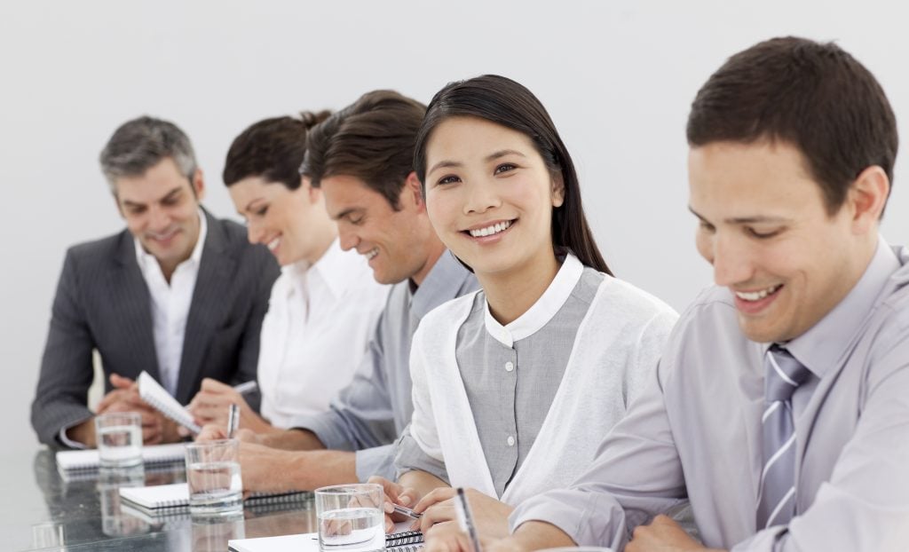 Smiling business partners taking notes in a meeting in the office