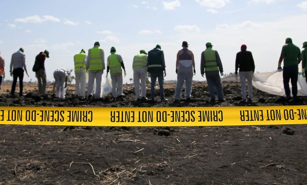 Forensics investigators and recovery teams collect personal effects and other materials from the crash site of Ethiopian Airlines Flight ET 302.