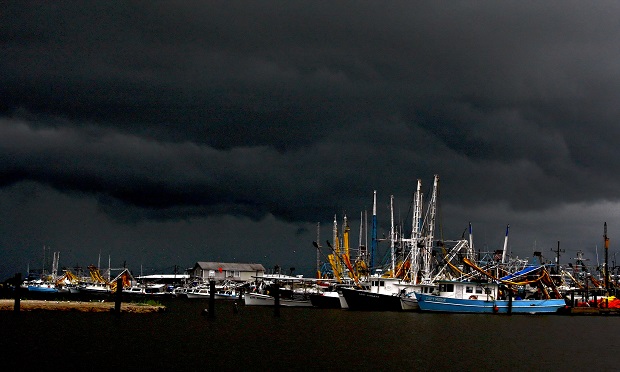 Storm clouds created by Hurricane Alex are seen over shrimp boats modified to skim oil in Port Fourchon, Louisiana, U.S., on Wednesday, June 30, 2010. Alex, the first hurricane of the Atlantic season, closed oil and gas platforms in the Gulf of Mexico and caused waves as high as 8 feet in the BP Plc Deepwater Horizon oil spill area. (Photo: Derick E. Hingle/Bloomberg)