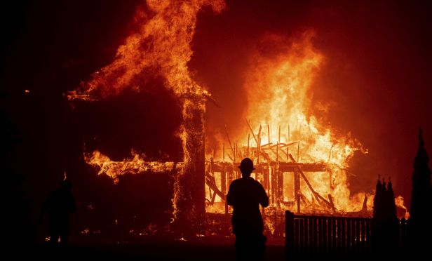 A home burns as the Camp Fire rages through Paradise, Calif., on Thursday, Nov. 8, 2018. Tens of thousands of people fled a fast-moving wildfire Thursday in Northern California, some clutching babies and pets as they abandoned vehicles and struck out on foot ahead of the flames that forced the evacuation of an entire town.(AP Photo/Noah Berger)