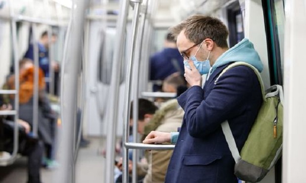 A man wearing a protective mask while commuting on a train. (Photo: Shutterstock)