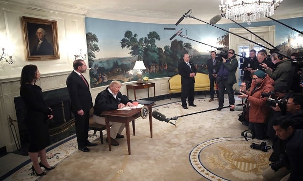 Donald Trump signs a coronavirus funding bill he signed at the White House on March 6, 2020.