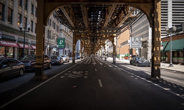 Elevated train tracks sit above a near-empty street in Chicago on April 3. (Photo: Christopher Dilts/Bloomberg)