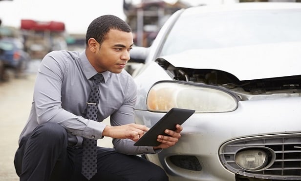 Young man using technology to document an auto claim.