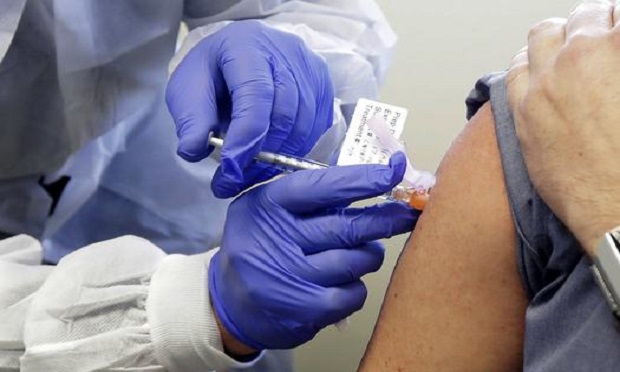 In this March 16, 2020, file photo, a patient receives a shot in the first-stage safety study clinical trial of a potential vaccine for COVID-19 at the Kaiser Permanente Washington Health Research Institute in Seattle. (AP Photo/Ted S. Warren, File)