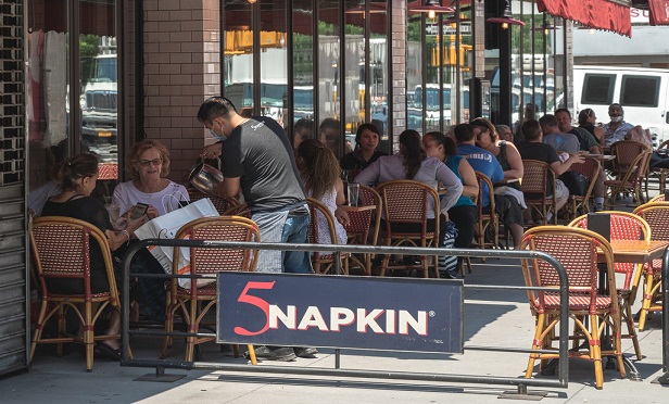 People sit outside restaraunt and eat lunch as NYC enters phase two of the reopening process. (Photo: Ryland West/ALM)
