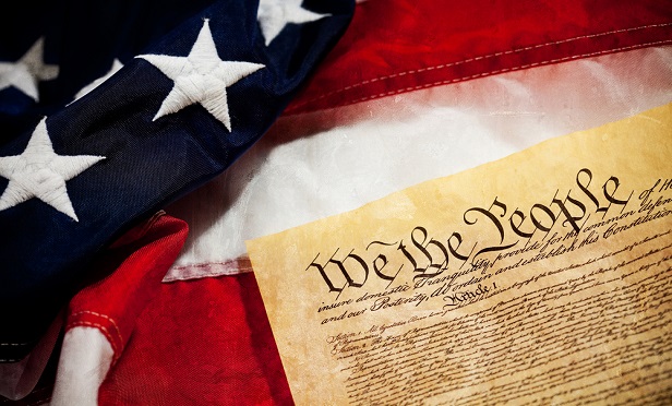 U.S. Constitution laying on an American flag.