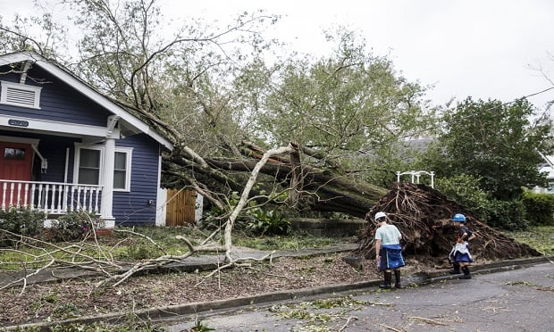Children look at a fallen tree lying on a damaged home after Hurricane Florence hit Wilmington, North Carolina, on Saturday, Sept. 16, 2018. (Photo: Alex Wroblewski/Bloomberg)