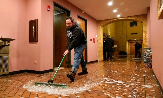 Father John Szatkowski of St. Paul The Apostle Church in Richardson, Texas, swept water from a broken water line out of his church on Wed., Feb. 17, 2021. Father Szatkowski and his staff found the flooding as they prepared for Ash Wednesday services. (AP Photo/Tony Gutierrez)