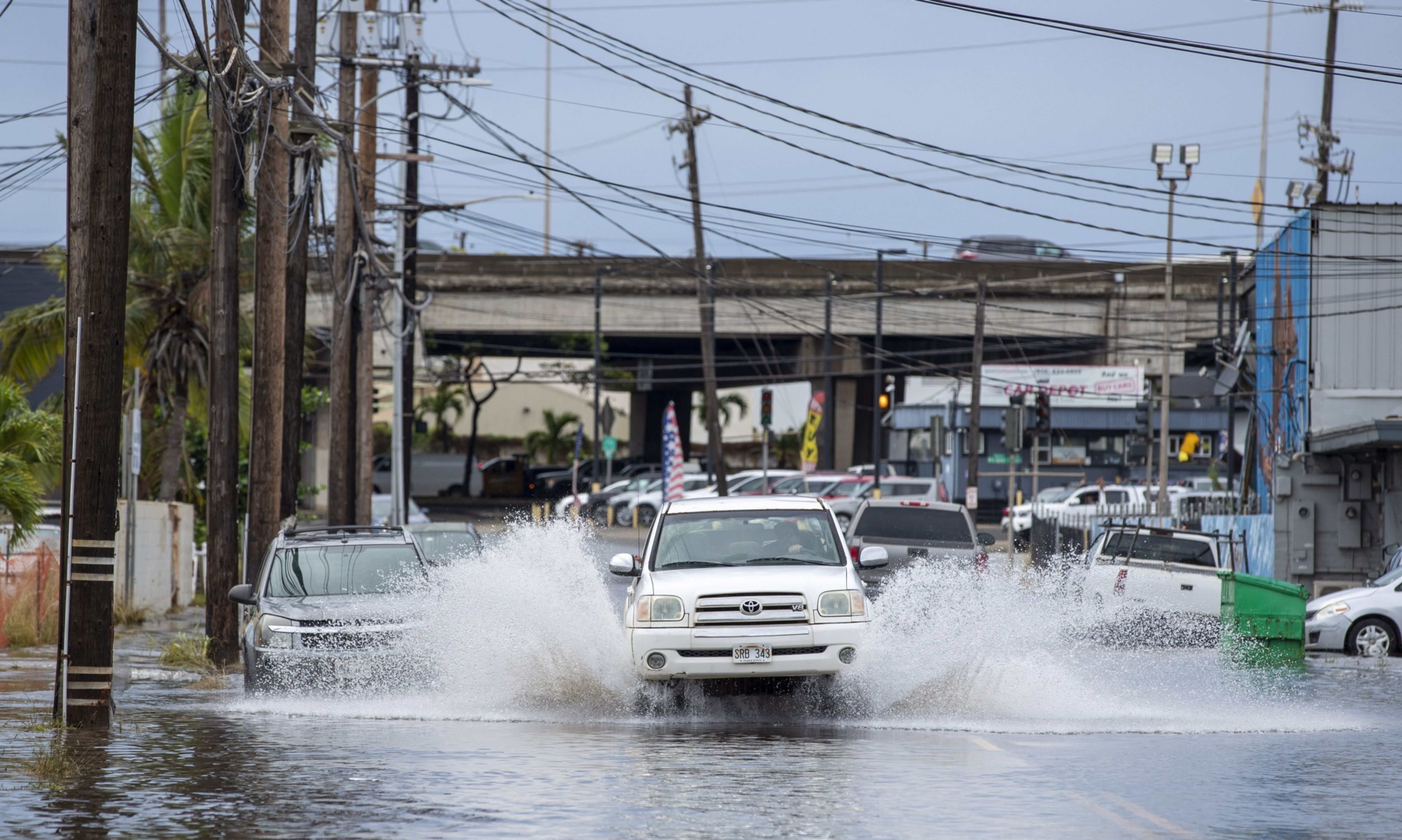 A pickup truck plows through a flooded street in Honolulu, Hawaii on Dec. 7, 2021. (Credit: Eugene Tanner/AFP/Getty Images)