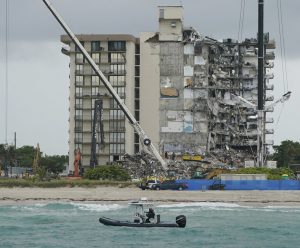 A Florida Fish and Wildlife Conservation law enforcement boat patrols in the ocean in front of search and rescue efforts at the Champlain Towers South condo building, where scores of people remain missing almost a week after it partially collapsed, Wednesday, June 30, 2021, in Surfside, Fla. (Credit: Lynne Sladky/AP)