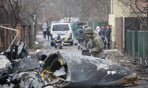 Un soldado del ejército ucraniano inspecciona los fragmentos de un avión derribado en Kiev, Ucrania, el viernes 25 de febrero de 2022. (Vadim Zamirovsky/AP)