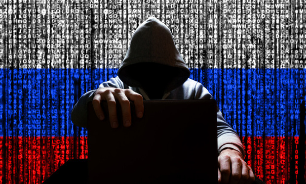 Russian hacker closes the lid of the laptop, against the backdrop of a binary code, the color of the Russian flag