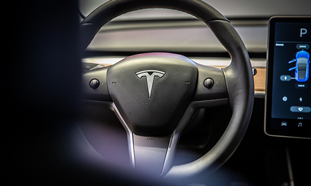 A sits on the steering wheel of a Tesla Inc. Model 3 electric vehicle in the Tesla store in Barcelona, Spain, on Thursday, July 11, 2019. Tesla is poised to increase production at its California car plant and is back in hiring mode, according to an internal email sent days after the company wrapped up a record quarter of deliveries.