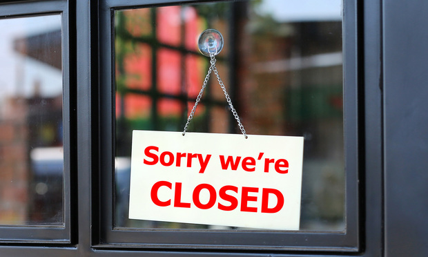 Sorry we're CLOSED sign board hanging on office door.
