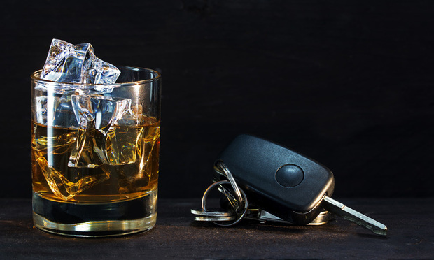 Whiskey glass with ice and car keys.
