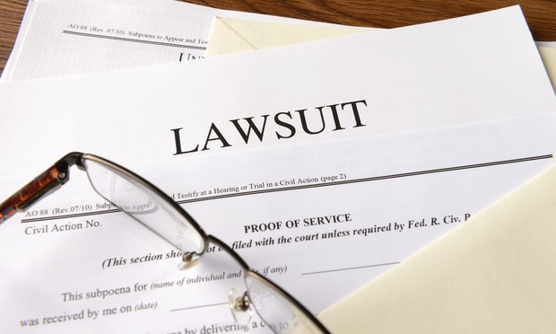 A pair of glasses lies on top of a lawsuit summons.