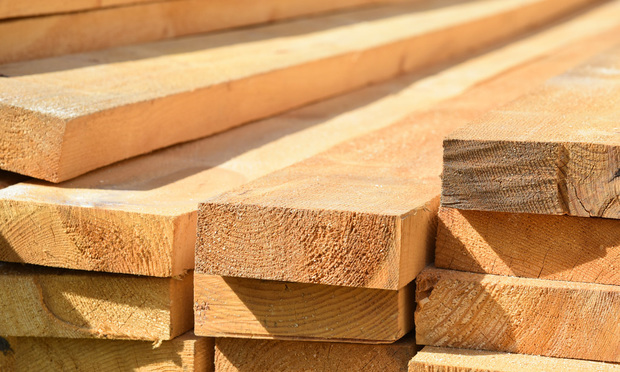 Pile of lumber, shot up close. Are developers asking for the moon on a stick when it comes to finding competitively priced P&C insurance for their frame construction projects? (Credit: Kononova Nina/Shutterstock.com)