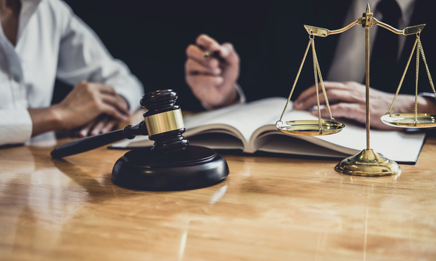 Male lawyer or judge hand's striking the gavel on sounding block, working at courtroom for decide home insurance, Law and justice concept, Settle a house dealing lawsuit// shutterstock