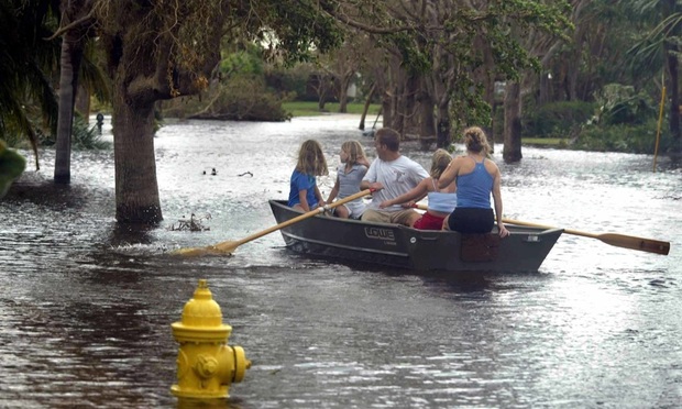 North Palm Beach-- 9/26/04-- J. Albert Diaz/Herald Staff- The Young family, L to R.. Lindsey,10, Katie, 8, dad Russ, Sarah, 9, and mom Annie paddle down the street from their home to check on some friends.
