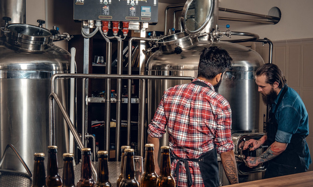 Men brewing beer in the craft brewery.