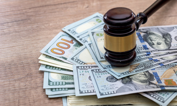 wooden gavel with usa dollar on desk. close up. Credit: ROMAN/Adobe Stock