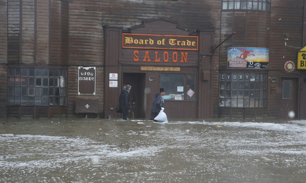 Two men walk through rushing water on Front Street, just a half block from the Bering Sea, in Nome, Alaska, on Saturday, Sept. 17, 2022. Much of Alaska's western coast could see flooding and high winds as the remnants of Typhoon Merbok moved into the Bering Sea region. The National Weather Service says some locations could experience the worst coastal flooding in 50 years. Photo: Peggy Fagerstrom/AP