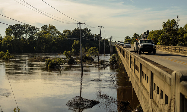 : Vehicles travel on a bridge across the Pearl River during a water shortage in Jackson, Mississippi, U.S., on Thursday, Sept. 1, 2022. The governor of Mississippi called in the National Guard to help residents of the state capital after a plant failure left at least 180,000 people in the area without access to safe water. (Credit: Houston Cofield/Bloomberg) 