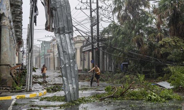 Fallen electricity lines, metal and tree branches litter a street after Hurricane Ian hit Pinar del Rio, Cuba, Tuesday, Sept. 27, 2022