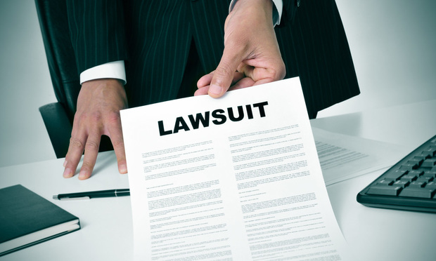 A person in a suit holds out a form that says "Lawsuit."